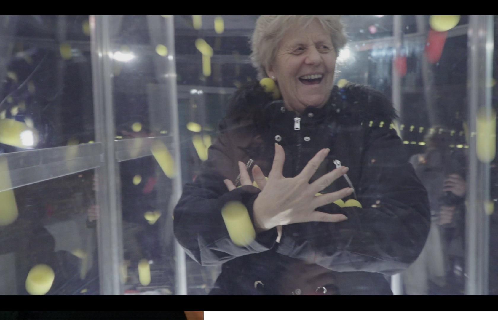 Hohe Glasvitrine mit Objekten darin vor weissem Hintergrund.