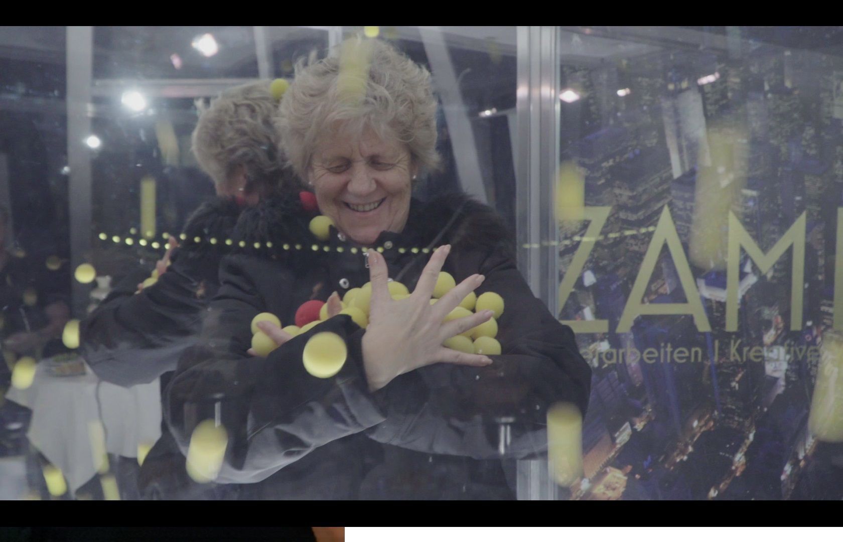 Hohe Glasvitrine mit Objekten darin vor weissem Hintergrund.