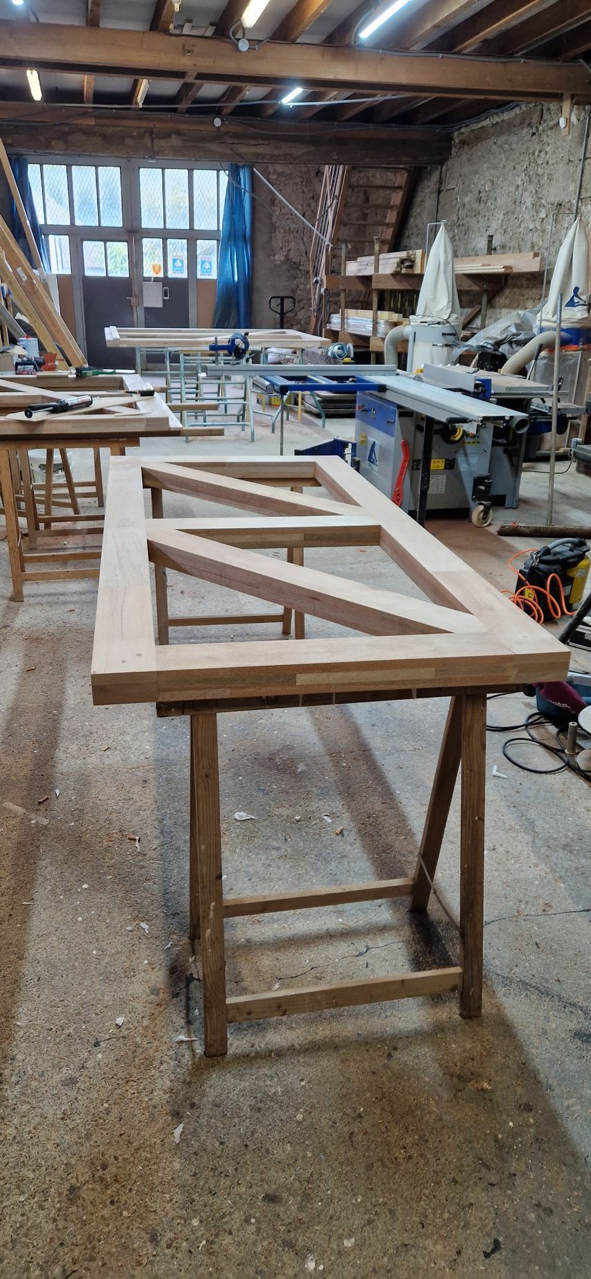 Des portes doubles blanches à vitres, dont une ouverte, donnent sur un intérieur.