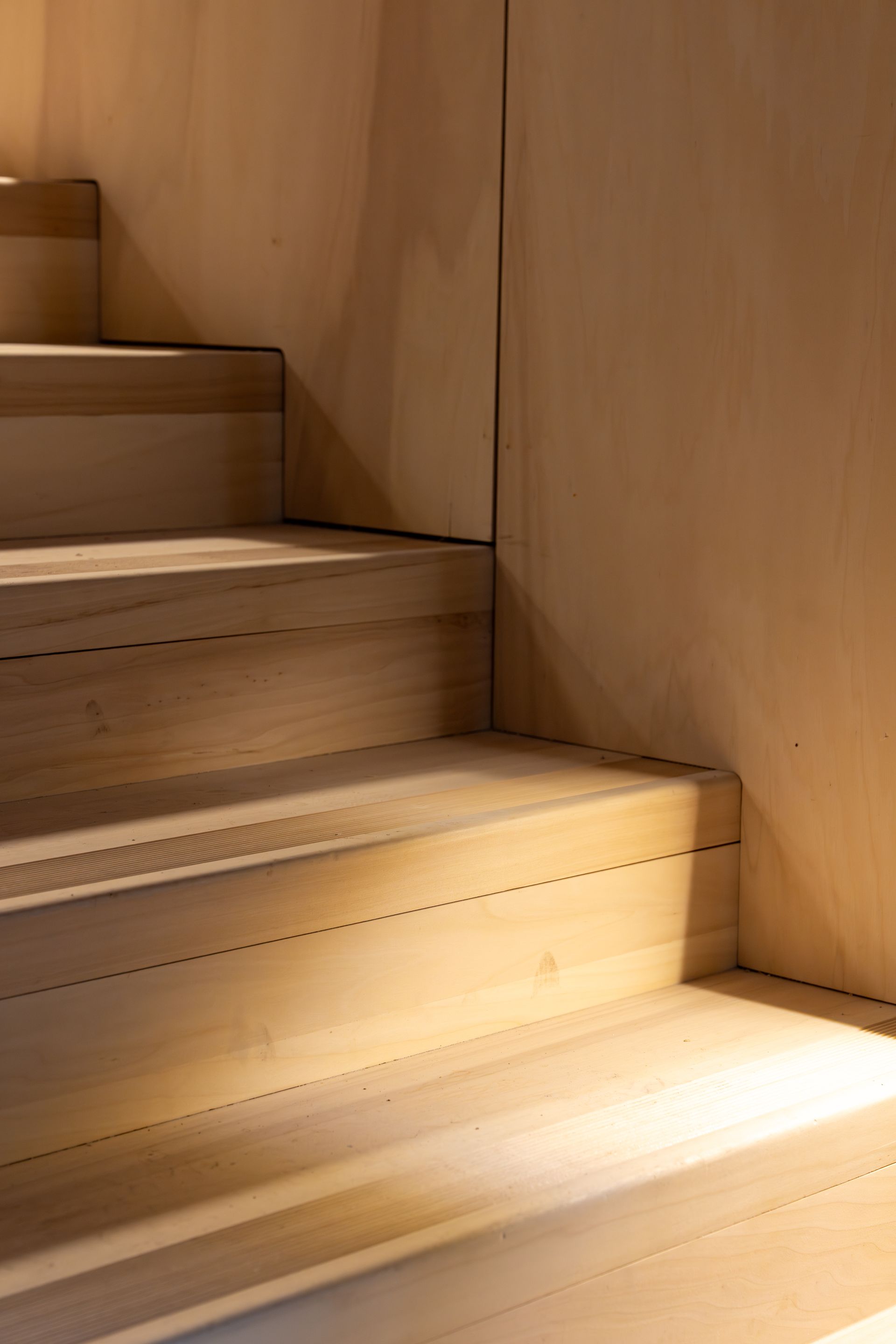 Escalier en bois avec une lumière chaude éclairant les marches et le mur