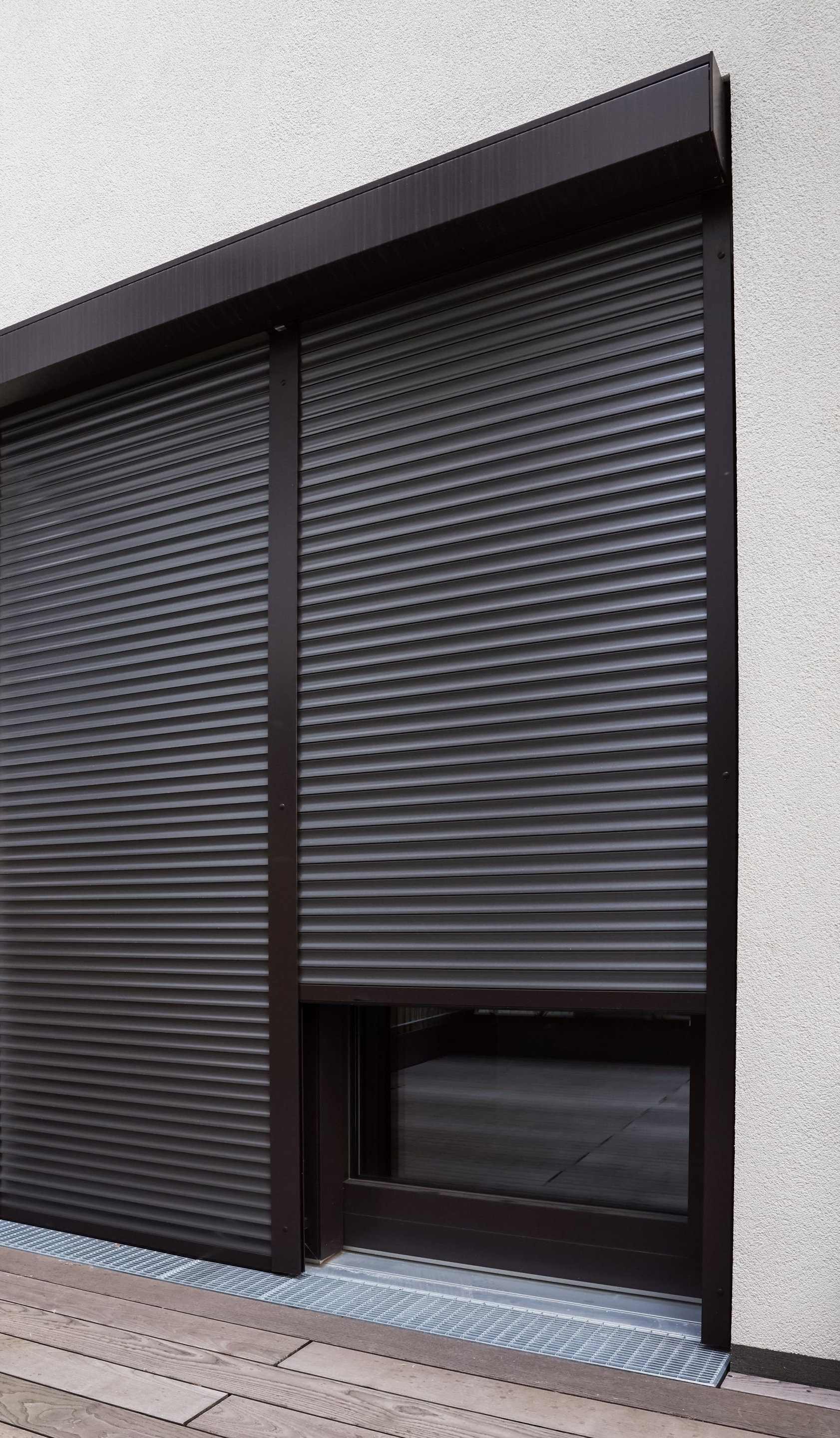 Mur extérieur avec volets gris foncé.