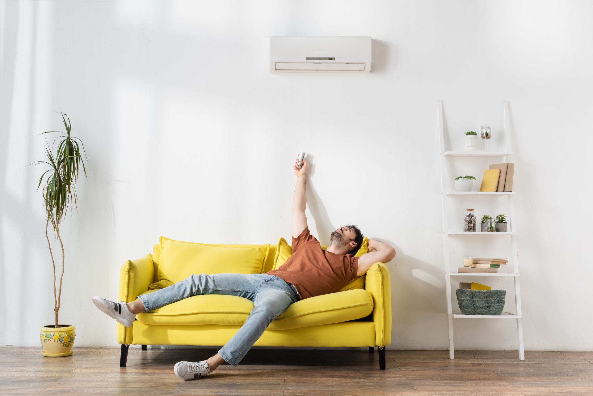 Homme en train d'allumer sa climatisation au-dessus de sa tête