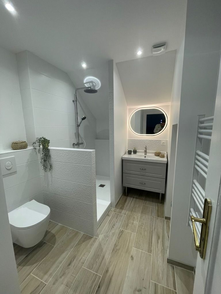 Salle de bains blanche avec un miroir allumé