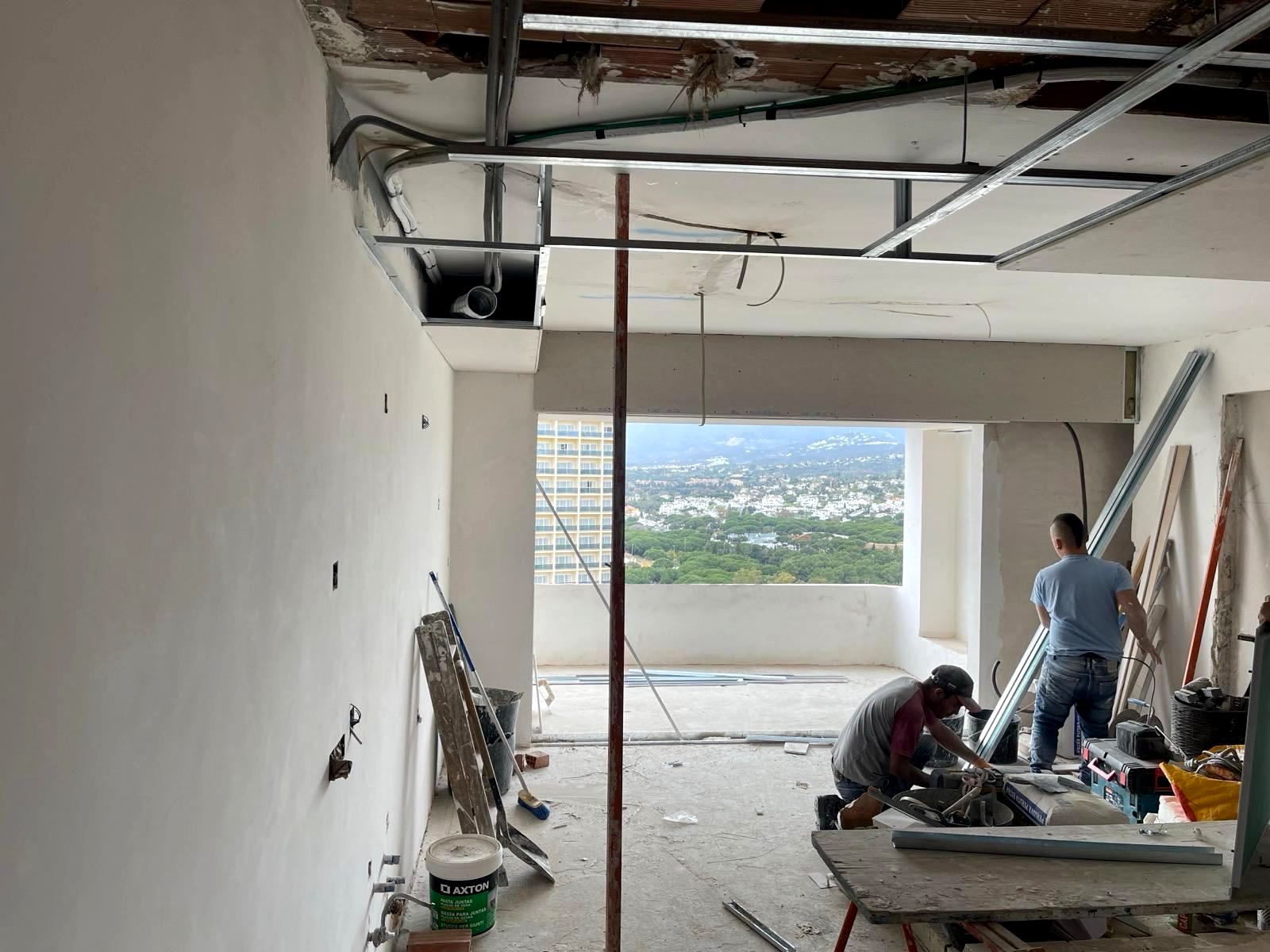 Un par de hombres están trabajando en una habitación en construcción.