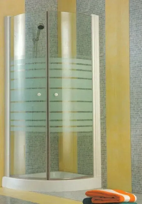 Box de chuveiro com vidro curvo e listras horizontais foscas, em um banheiro.