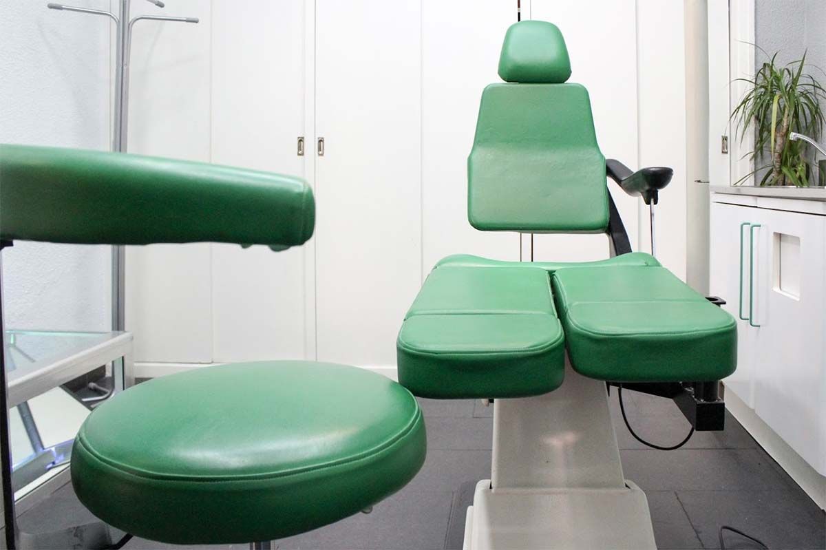 En un consultorio dental hay una silla dental verde.