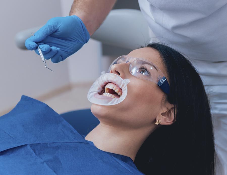 Una mujer se está haciendo examinar los dientes por un dentista.