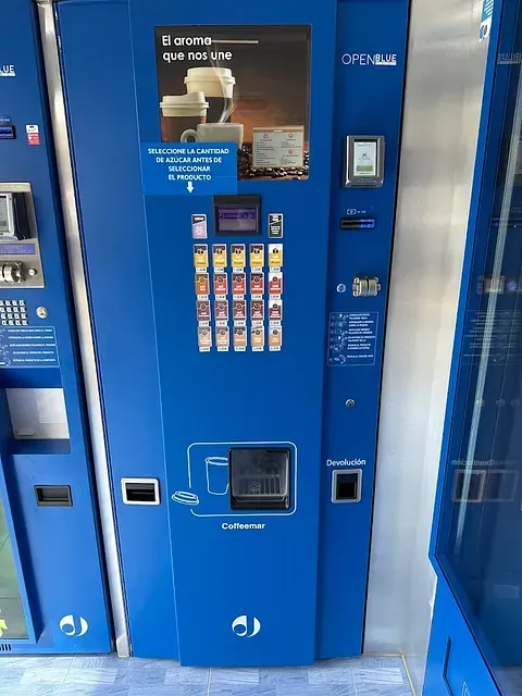 Una máquina expendedora azul con la imagen de una taza de café.