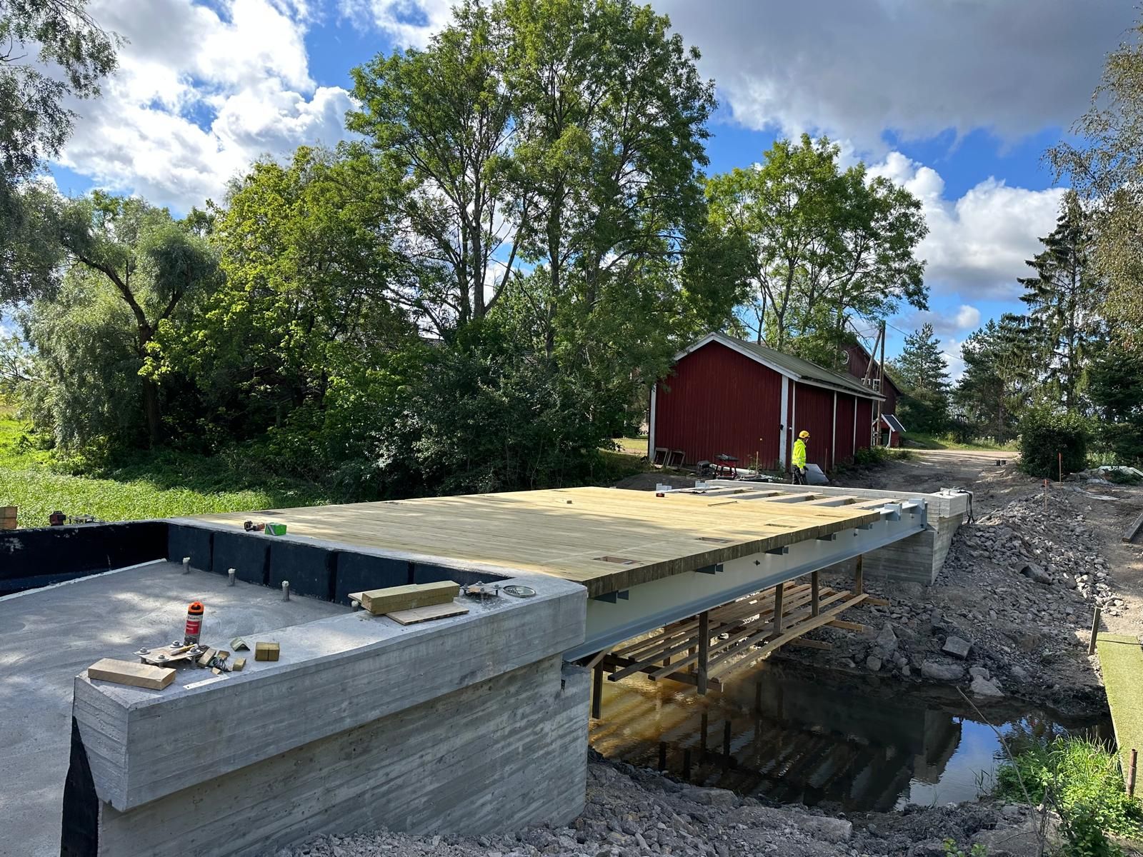 Teräsrunkoisen sillan kansilankutus ja paikallavaletut betonimaatuet infratyömaalla.