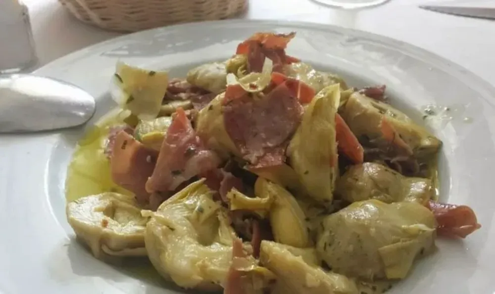 Corazones de alcachofa con jamón en un plato blanco.