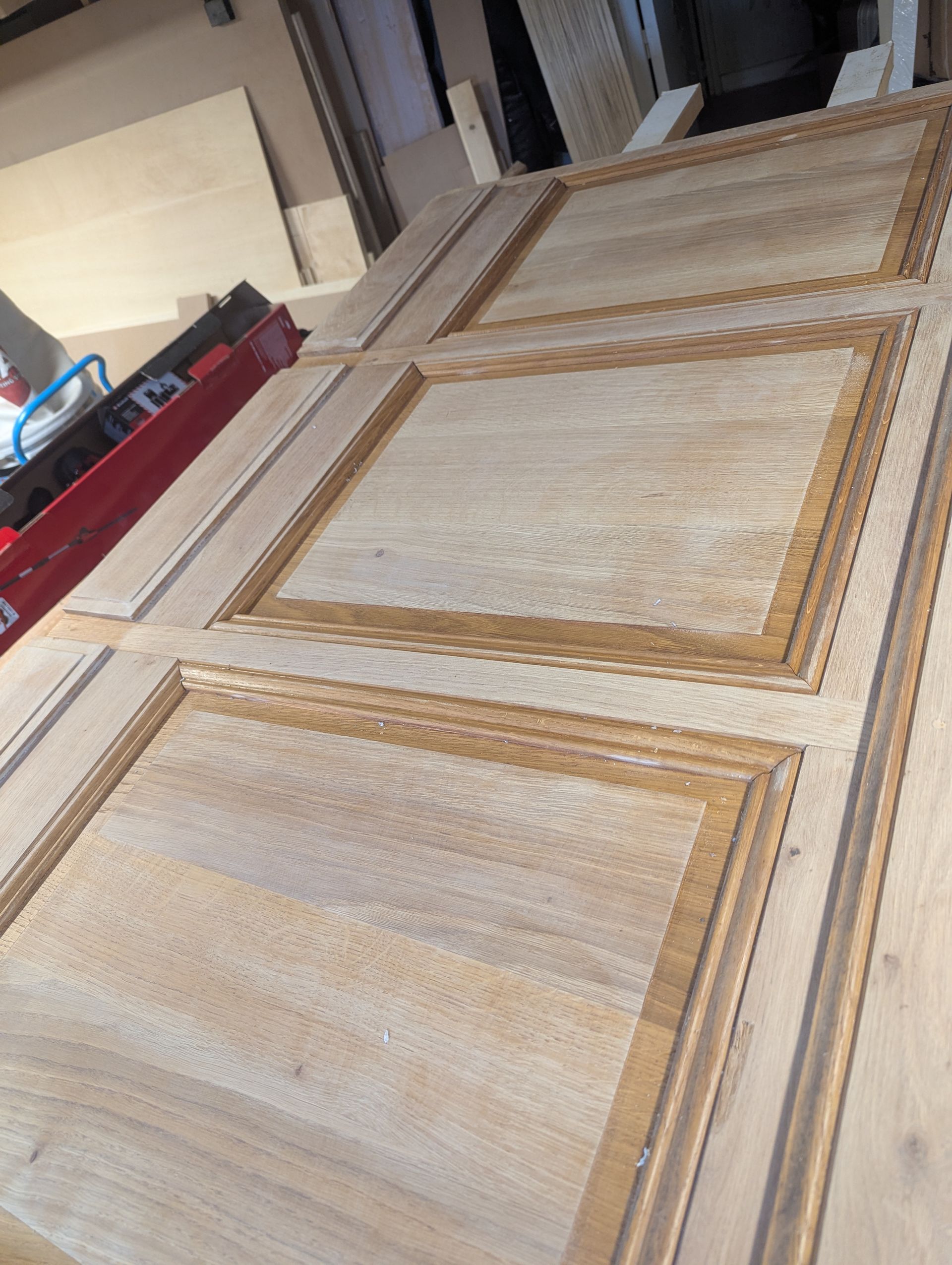 Panneaux de porte en bois avec carrés en retrait et garniture décorative, éventuellement destinés à un meuble.