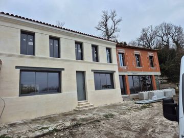 Rangée de maisons de ville inachevées aux façades grises et oranges sur un chantier boueux
