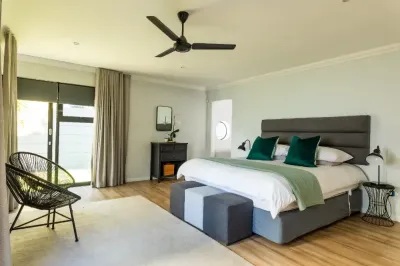 A bedroom with a large bed and a ceiling fan.