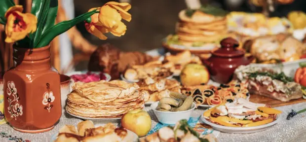 A table topped with plates of food and a vase of flowers.