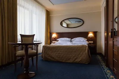 A hotel room with a large bed and a table
