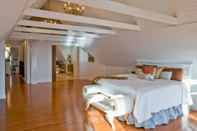 A bedroom with a large bed and a bench
