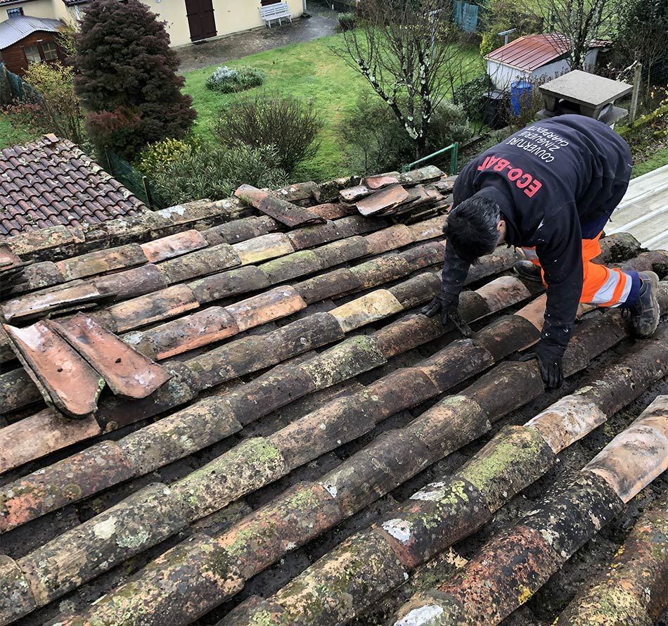 Artisan d'Ecobat Aquitaine accroupi sur une toiture