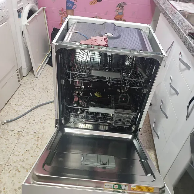 Lavavajillas abierto que muestra las rejillas interiores y los componentes.