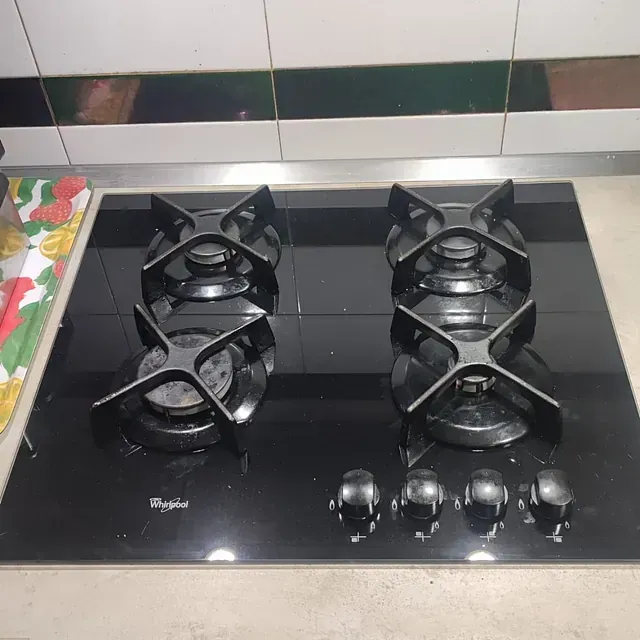 Cocina a gas Whirlpool color negro con cuatro quemadores y perillas de control.