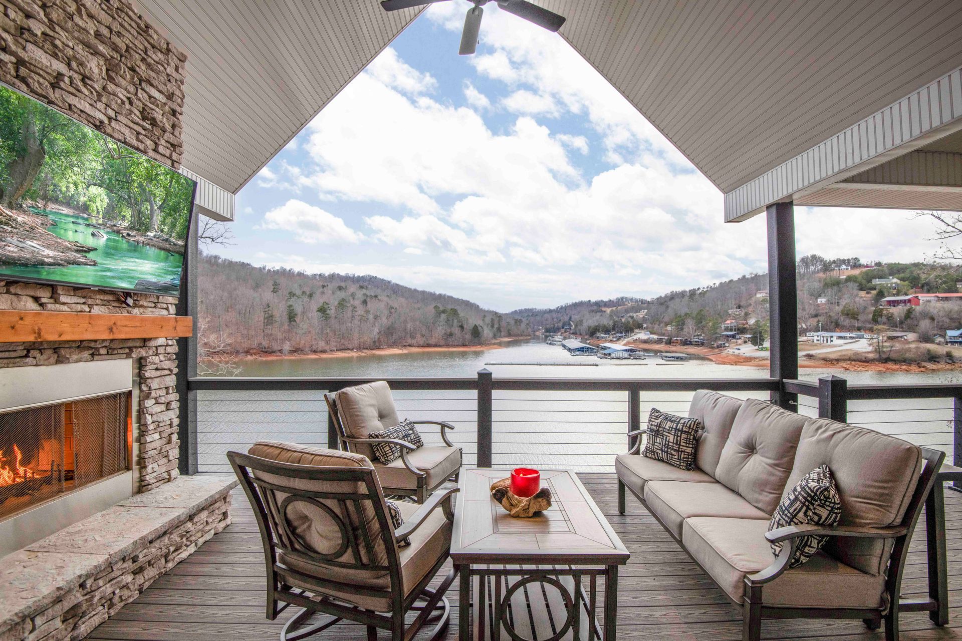 Outdoor deck with lake view, fireplace, and seating.