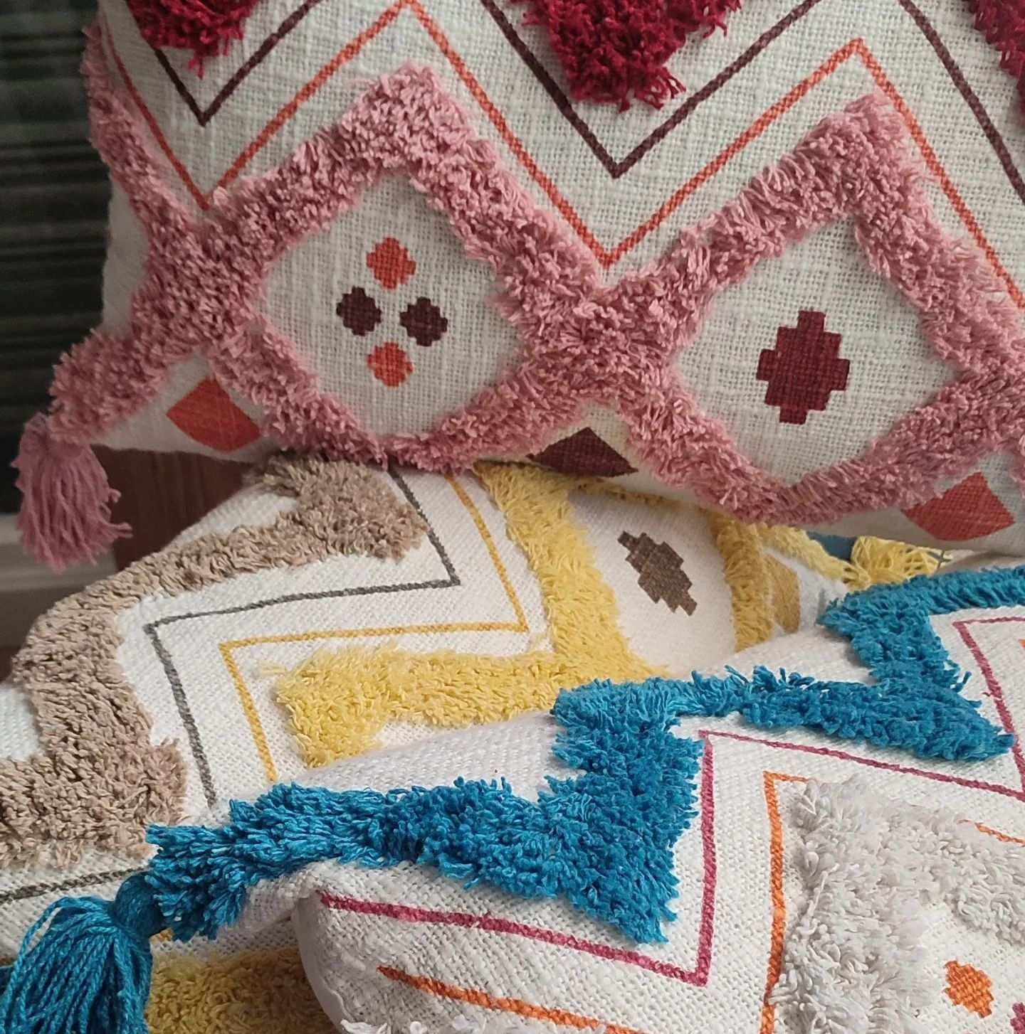 Una pila de almohadas de colores colocadas una encima de otra.