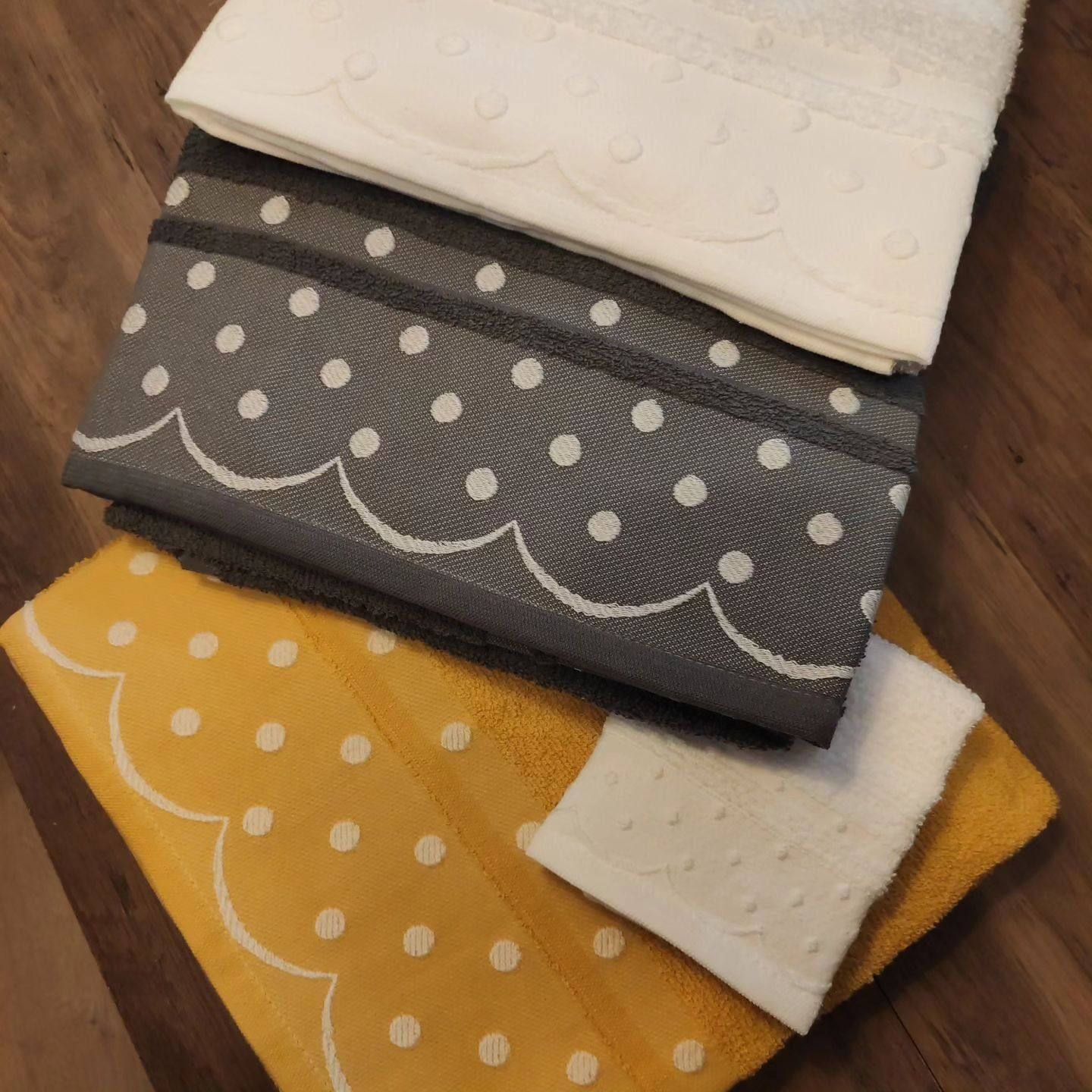 Tres toallas están apiladas una encima de otra sobre una mesa de madera.