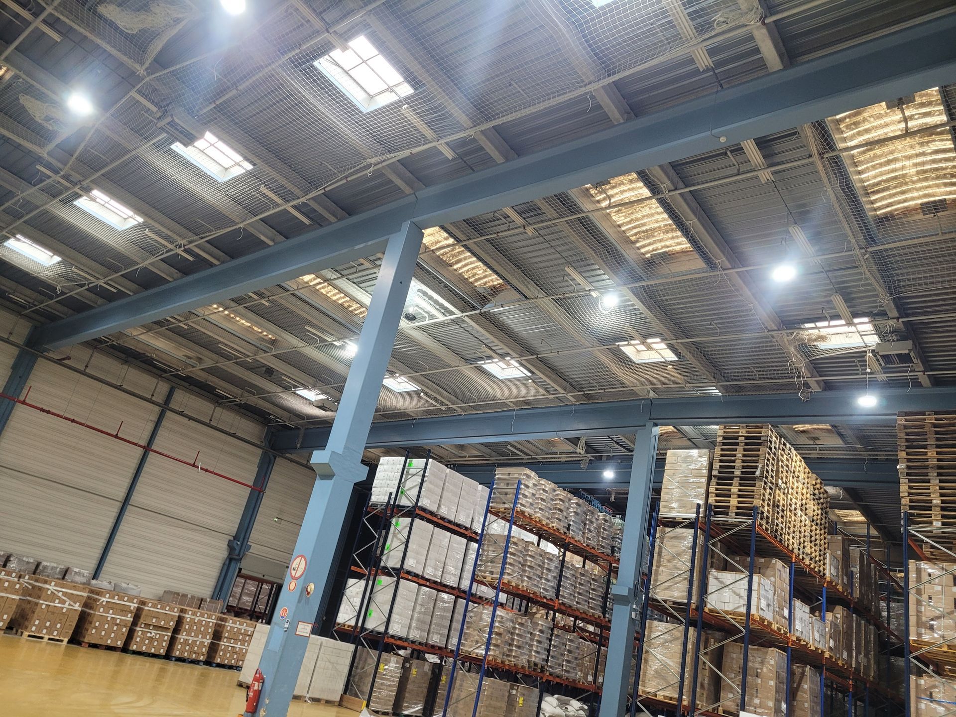 Intérieur d'un grand entrepôt avec un filet de sécurité.