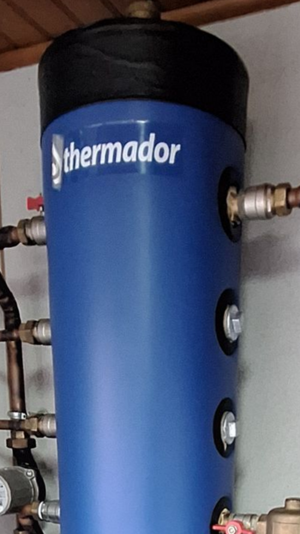 Chauffe-eau bleu fixé sur un mur