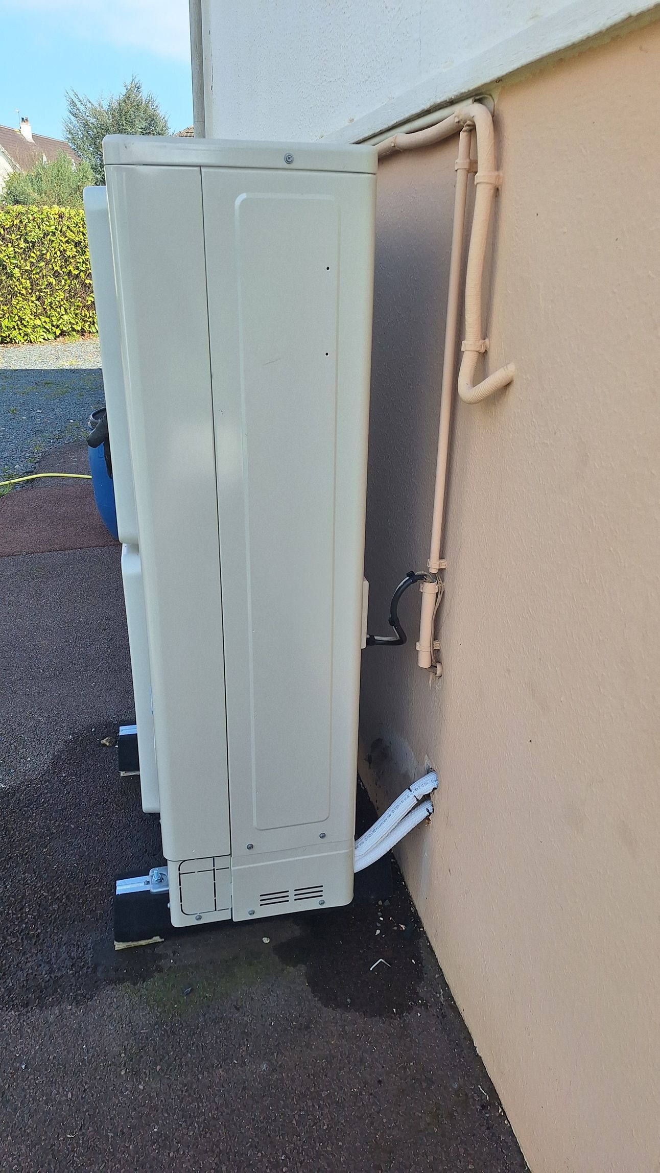 Plusieurs unités de climatisation blanches montées sur un mur extérieur, avec des tuyaux en cuivre.