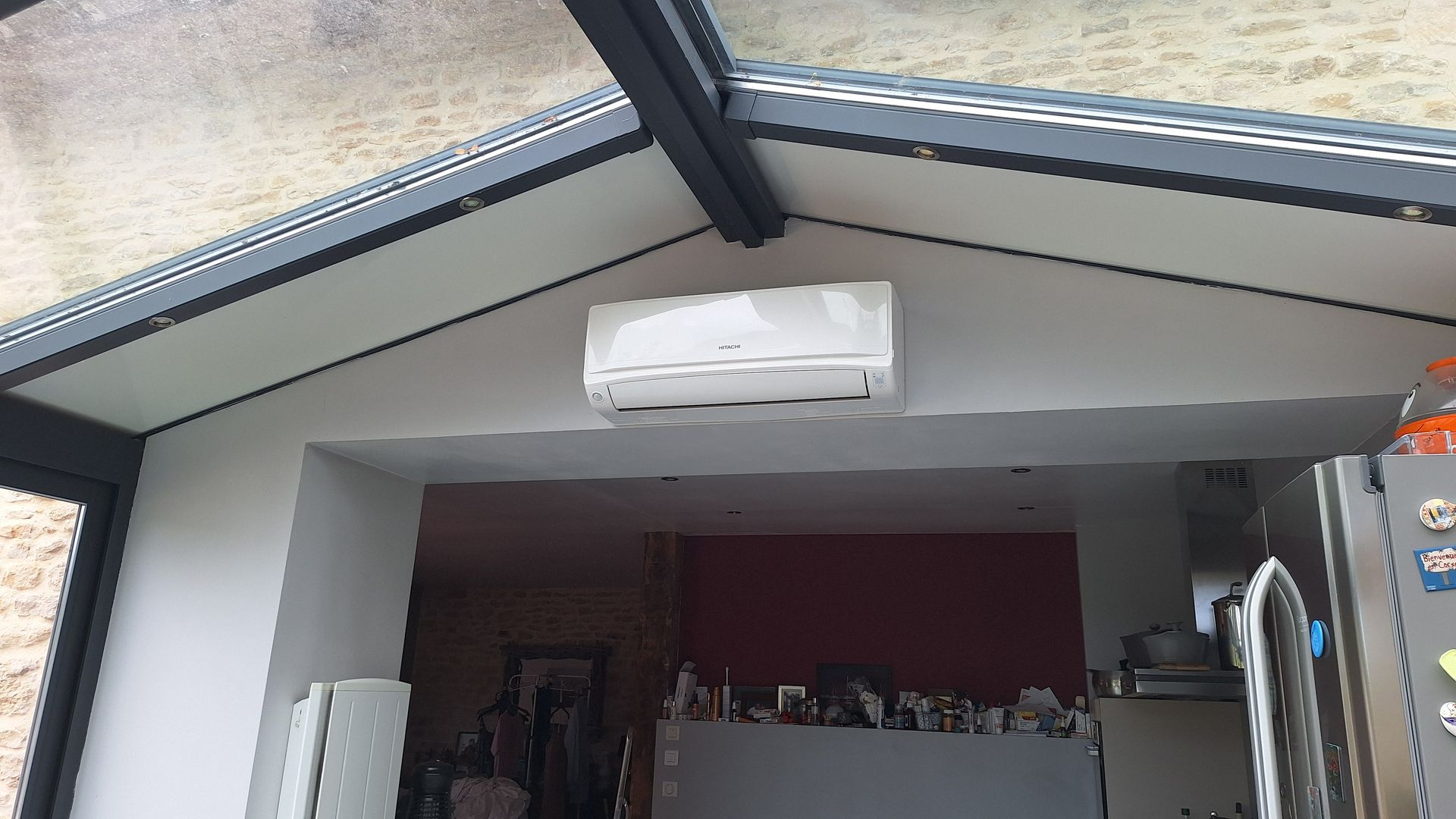 Climatiseur blanc monté sur un mur blanc dans une véranda.