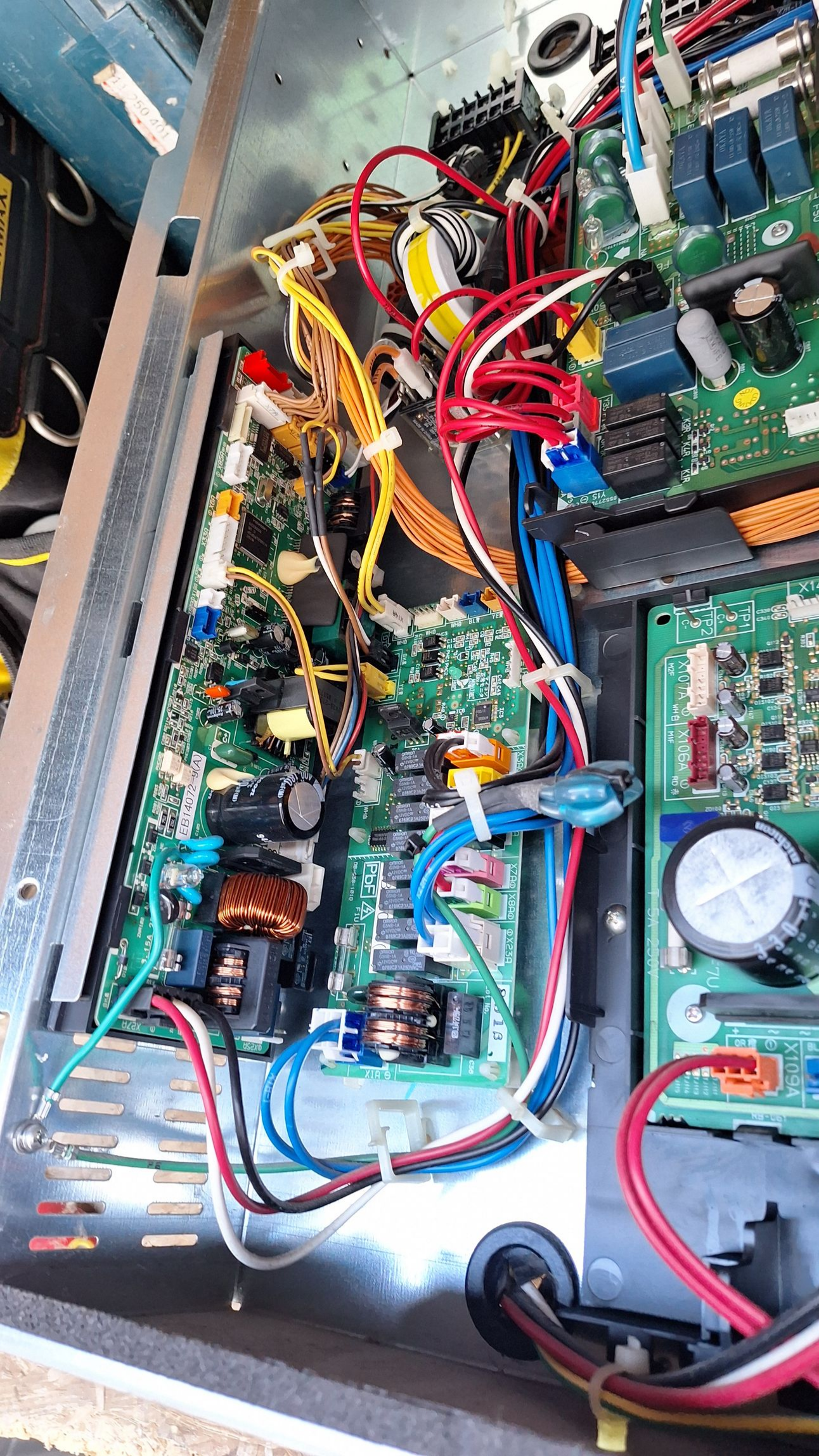 Circuits imprimés avec fils colorés à l'intérieur d'un châssis métallique.
