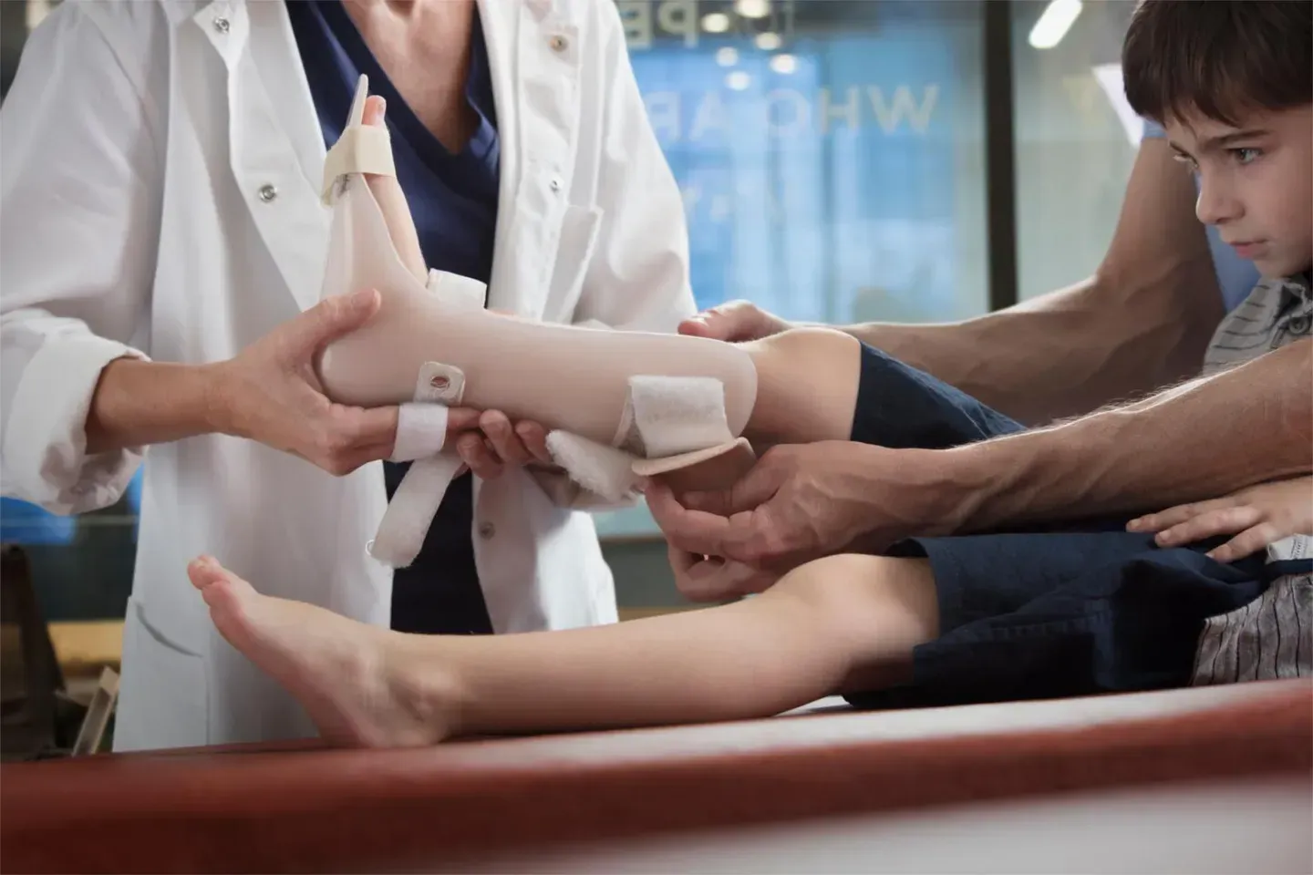 Pharmacien installant une orthèse au pied d'un enfant