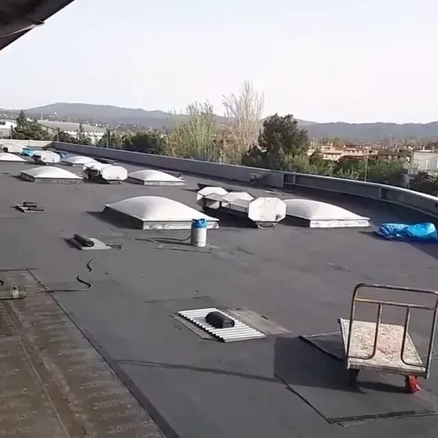 Un techo con un carro encima y muchos tragaluces sobre él.