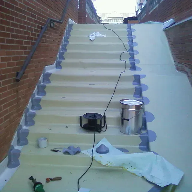 Se está pintando una escalera con una lata de pintura.