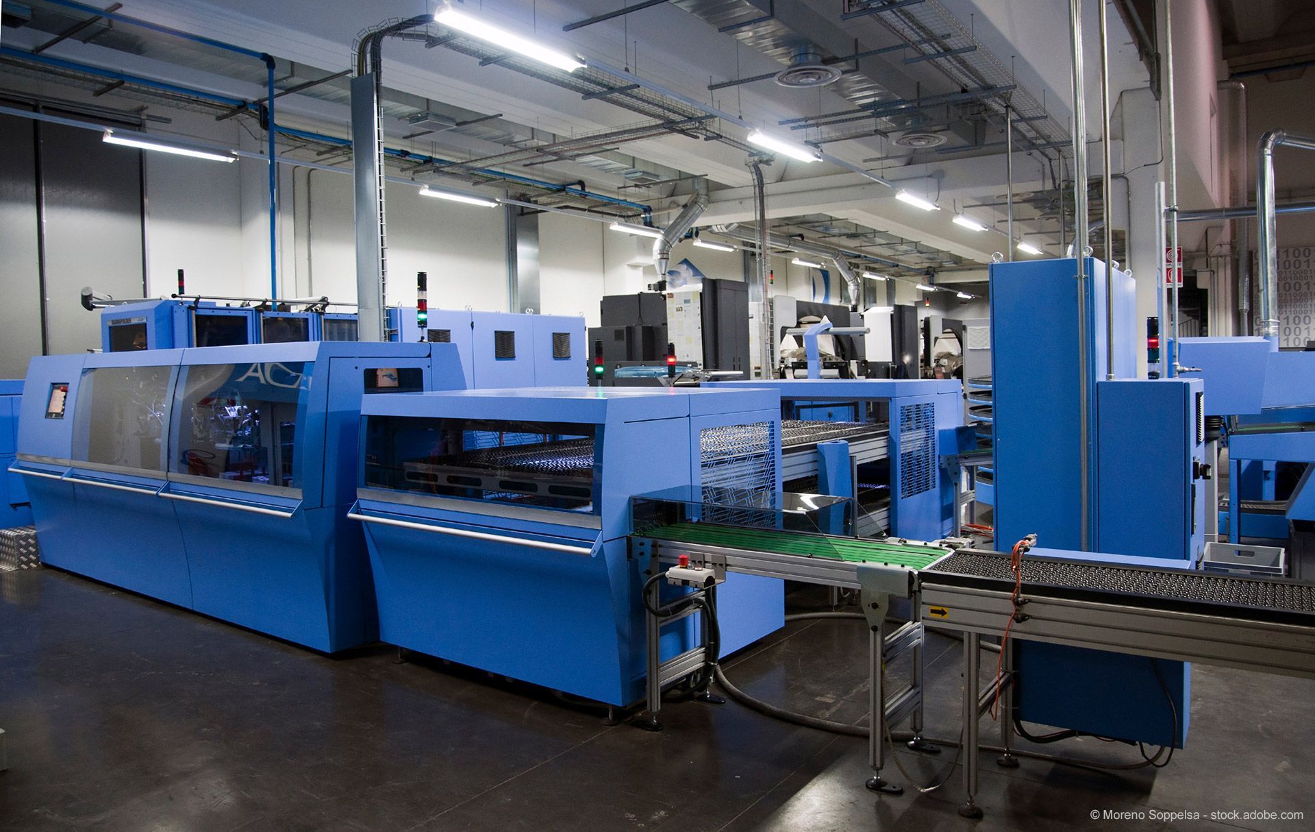 Blaue Industriemaschinen in einer Fabrikhalle.