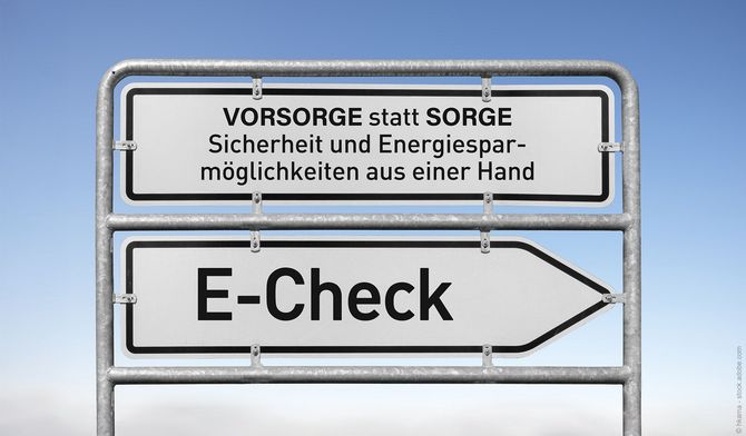 Hinweisschild mit der Aufschrift „Vorsorge statt Sorge“ über „E-Check“, das auf Sicherheit und Energieeinsparung hinweist.