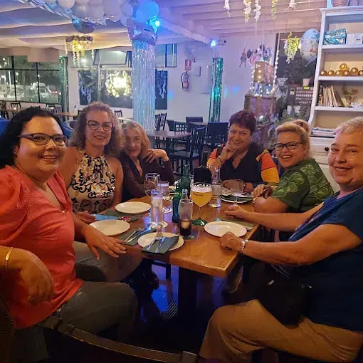 Un grupo de mujeres están sentadas alrededor de una mesa en un restaurante.