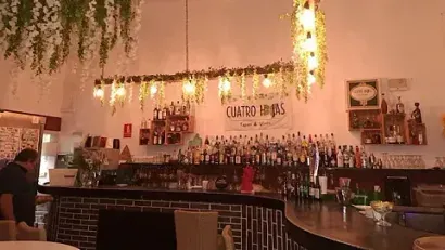 Un hombre está sentado en una barra de un restaurante.