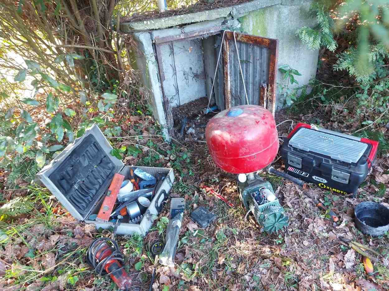 Caja de herramientas abierta junto a un tanque de combustible rojo y maletas negras.