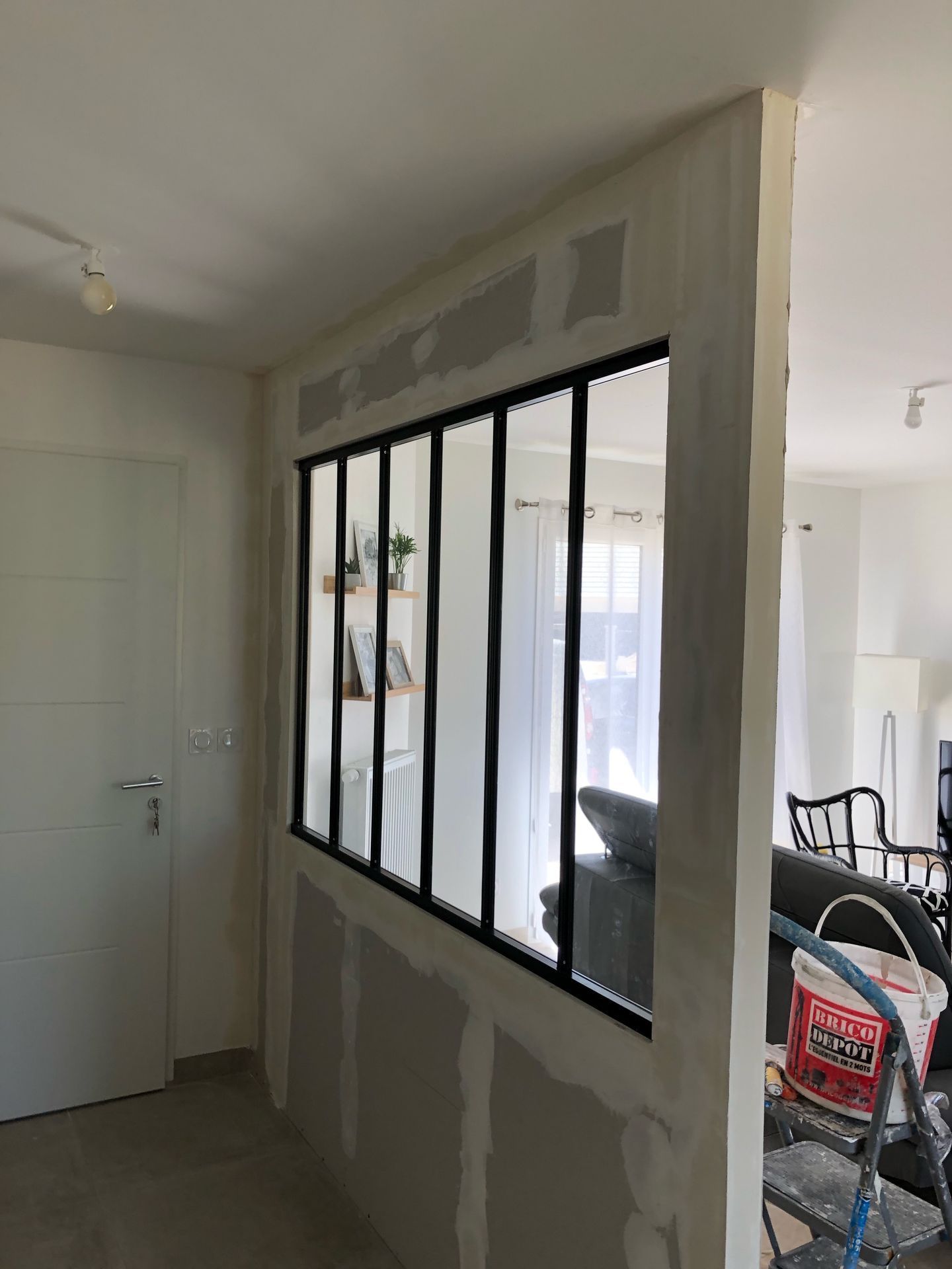 Une cloison vitrée en plaque de plâtre.