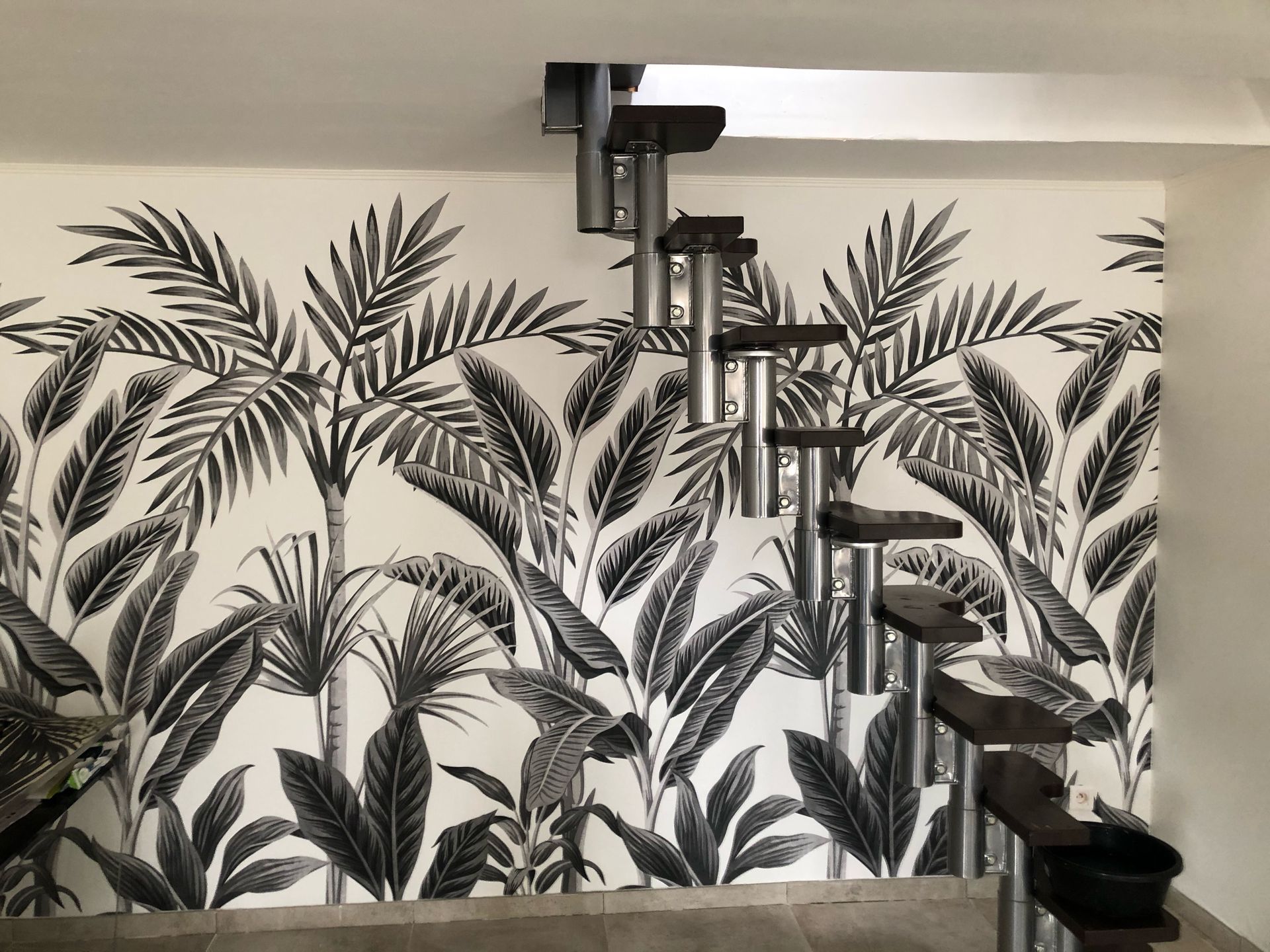 Du papier peint noir et blanc derrière un escalier.