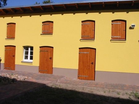 Abbildung Arbeitsbeispiel Tischlerei Weinland: Hölzerne Fensterläden an gelben Haus