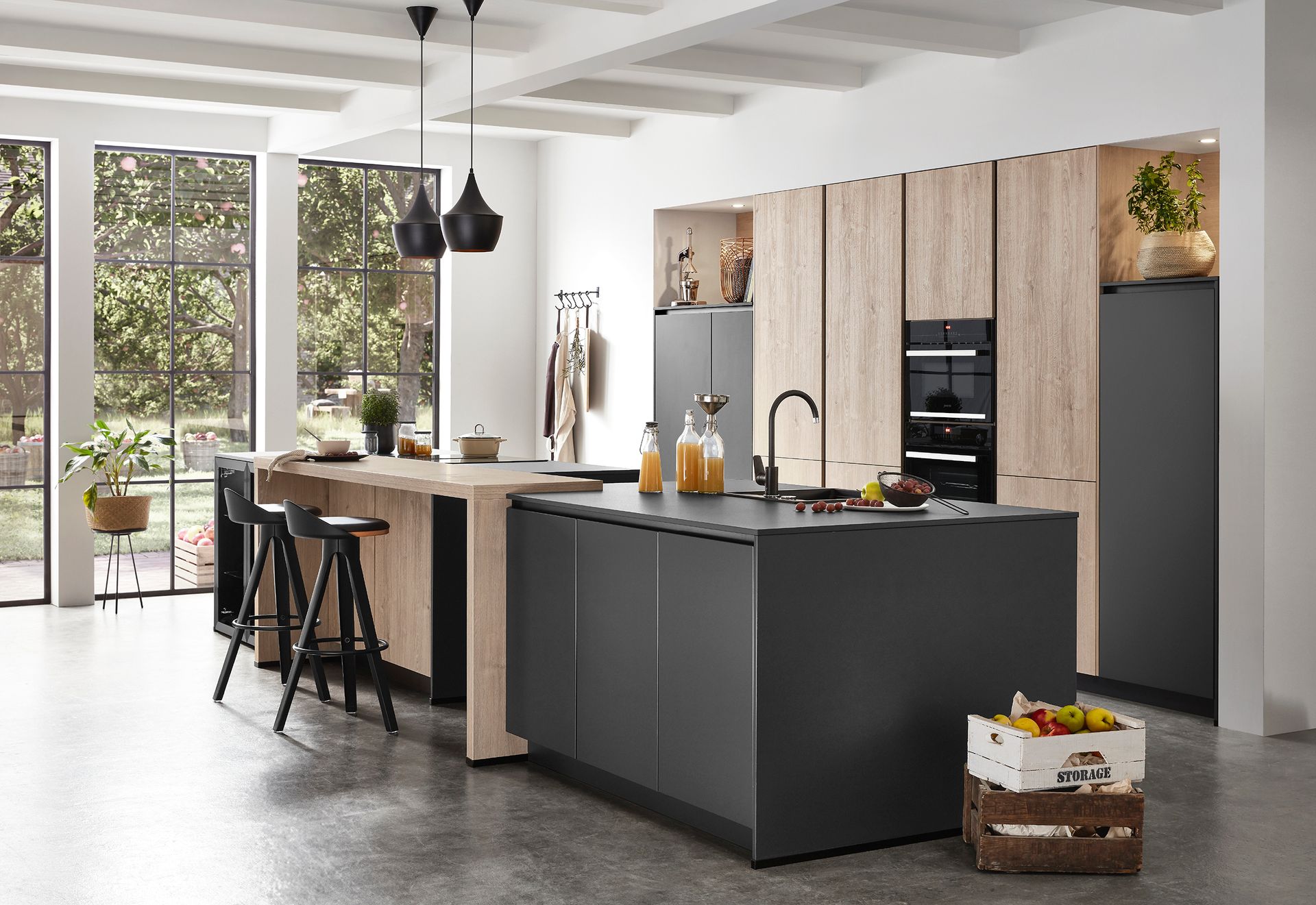 Cocina moderna con dos islas. Una de madera con taburetes, la otra gris con grifo.