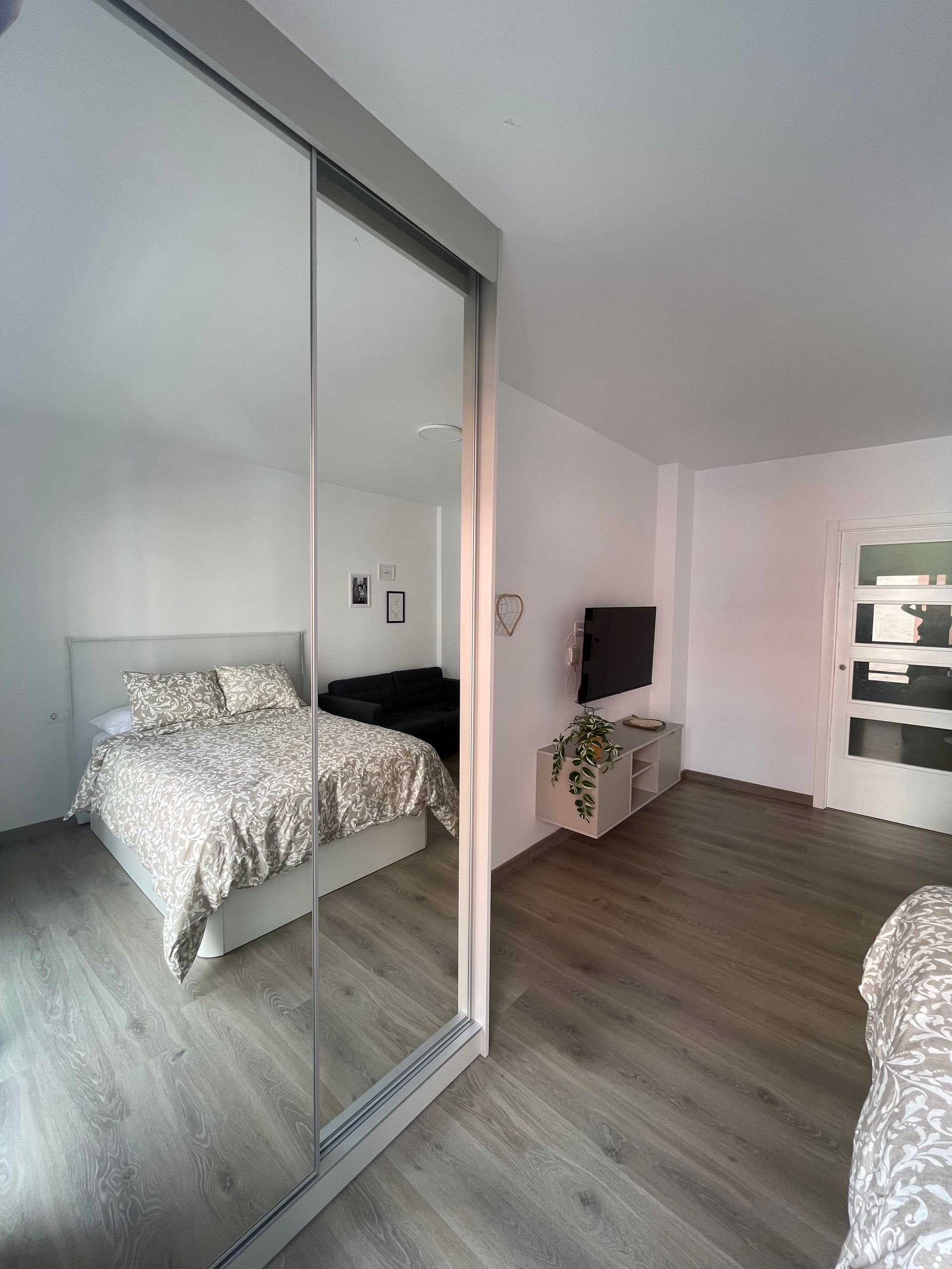 Un dormitorio con una cama y un televisor.