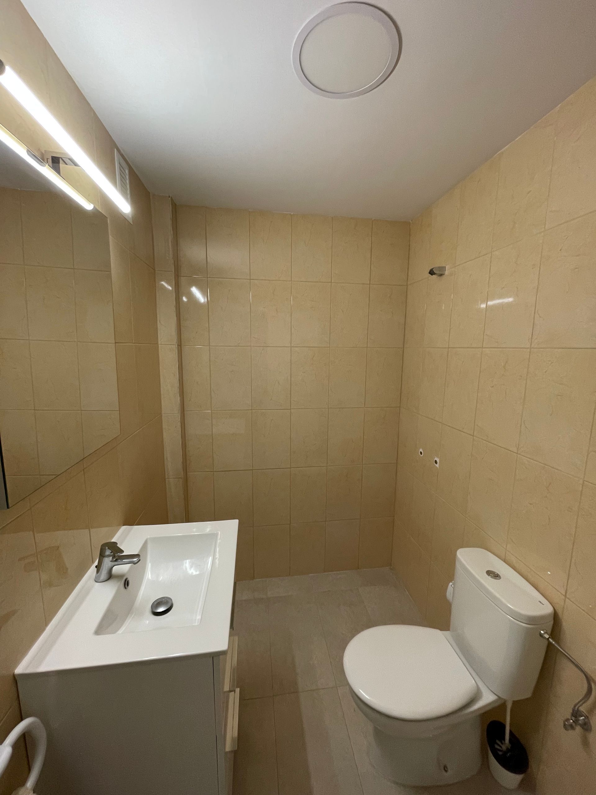 Un baño con inodoro, lavabo y espejo.