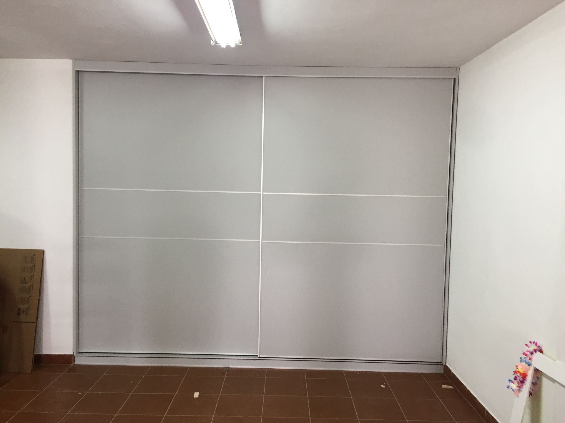 Una habitación con una puerta corrediza de vidrio entre dos paredes.