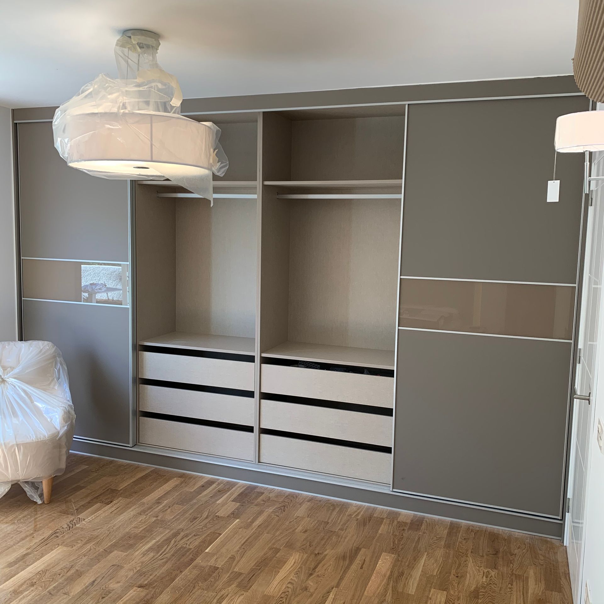 Un armario grande con puertas corredizas y cajones en una habitación.