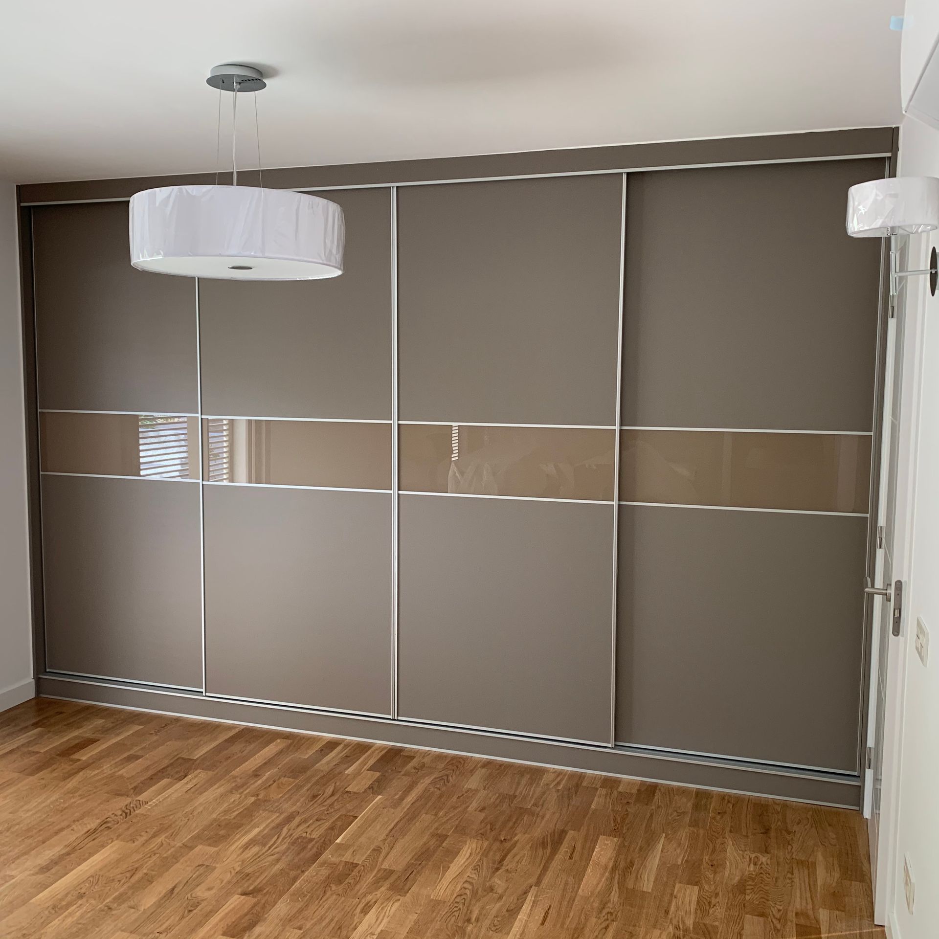 Un dormitorio con puertas corredizas de vidrio y una lámpara colgando del techo.