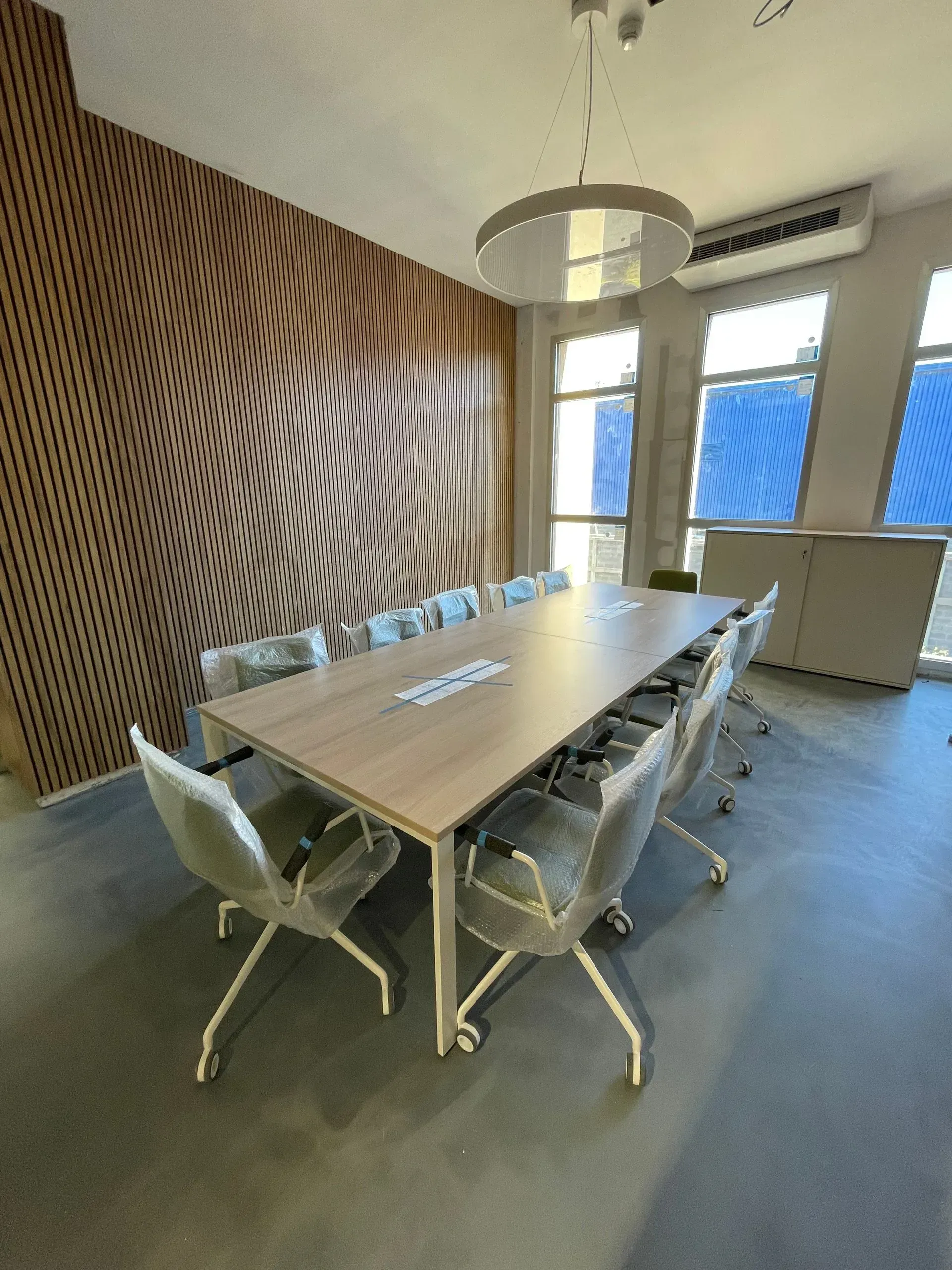 Una sala de conferencias con una mesa larga y sillas.