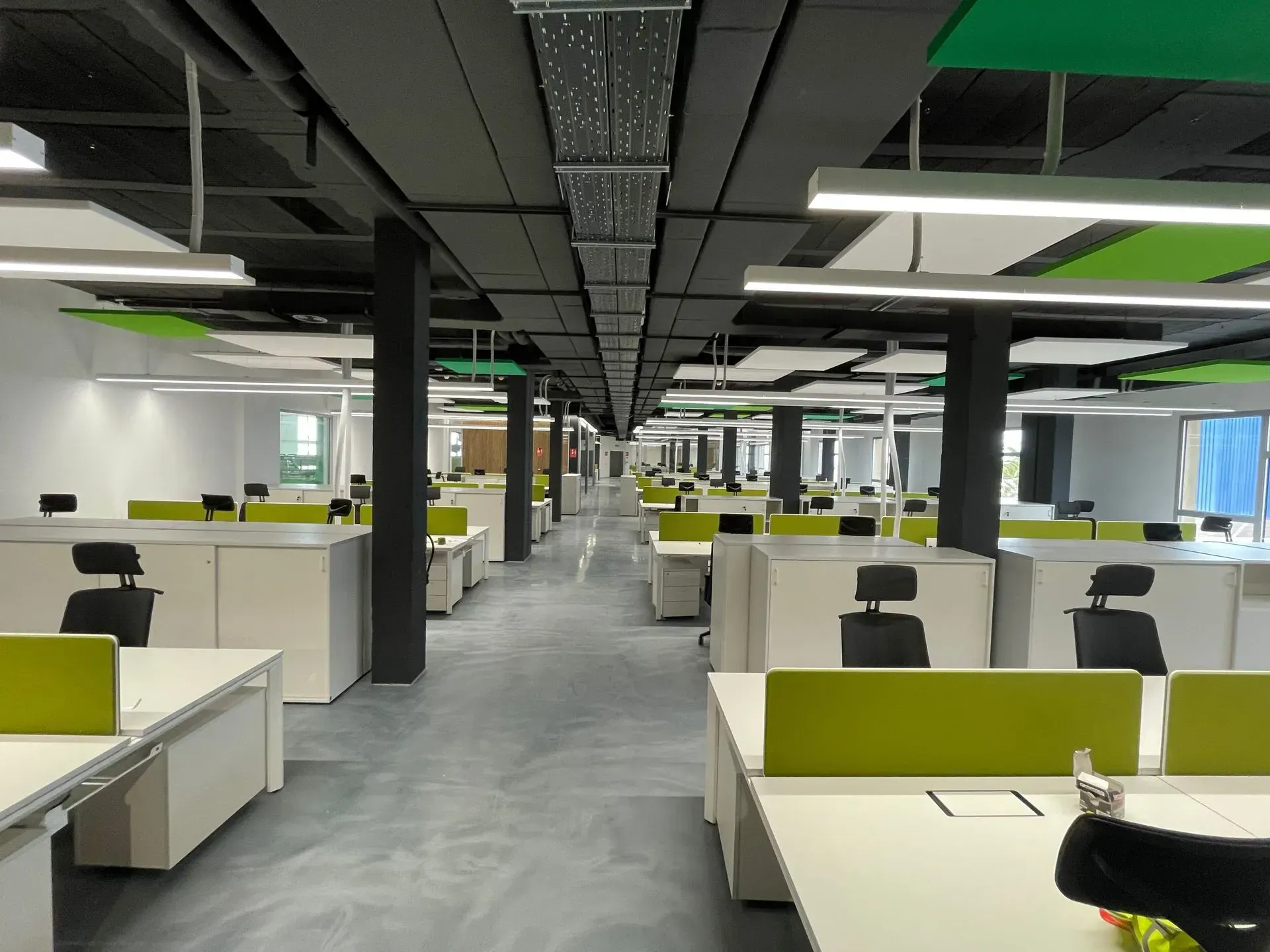 Una oficina grande con muchos escritorios y sillas.